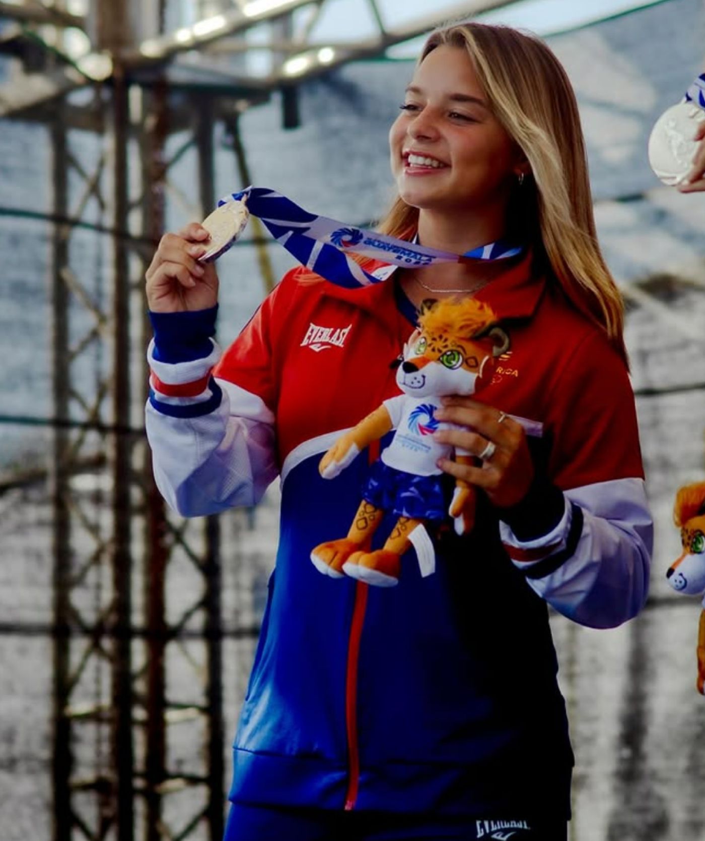 A young athlete smiles holding up her medal
